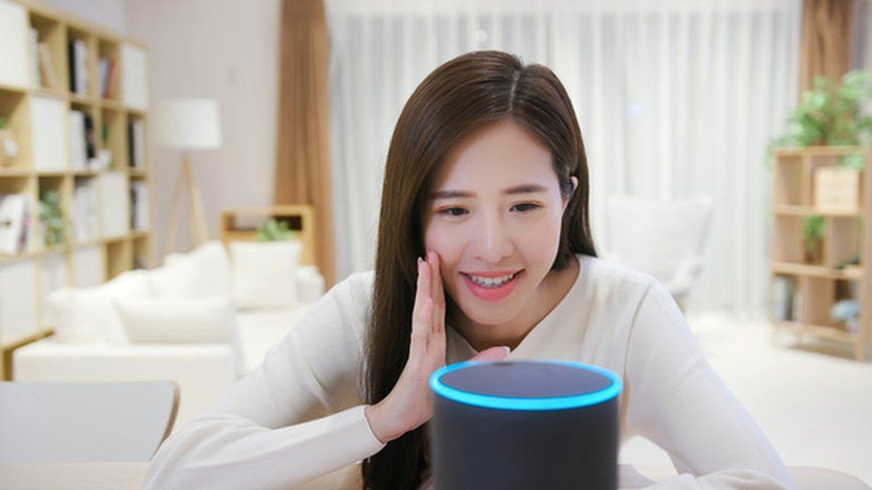 Woman talking to Alexa via a smart speaker