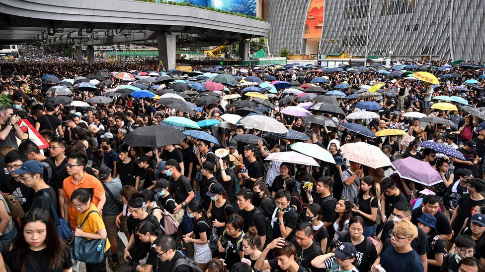 Protesters carry umbrellas during a march to the West Kowloon rail terminus against the proposed extradition bill and before a clash with police in the Mong Kok district in Kowloon in Hong Kong on July 7, 2019