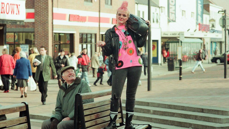 A woman stands with a cassette player in Redcar, England in 1997