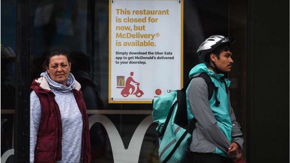 A delivery driver waiting outside a McDonald's restaurant in Tooting