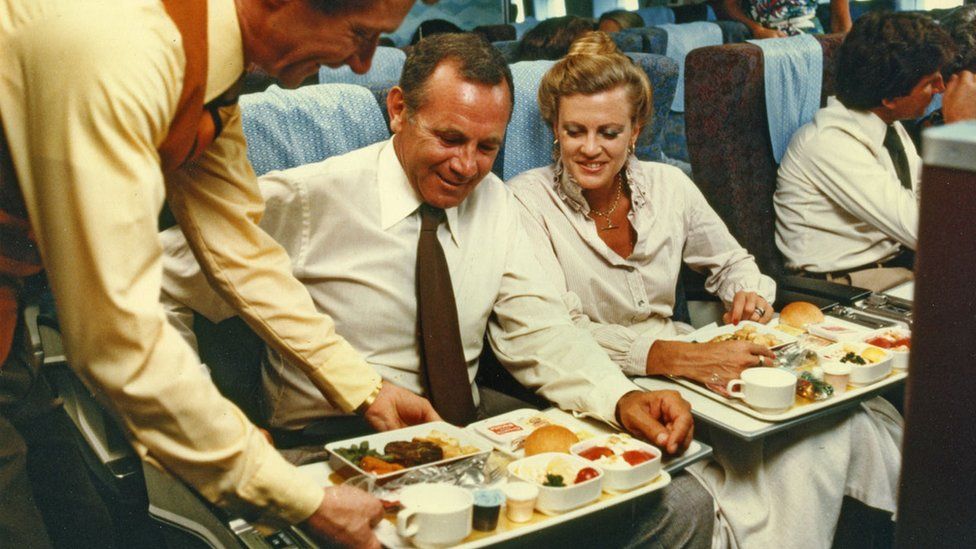 A couple receive a plane meal in the economy cabin of a Qantas B747B in the 1970s.