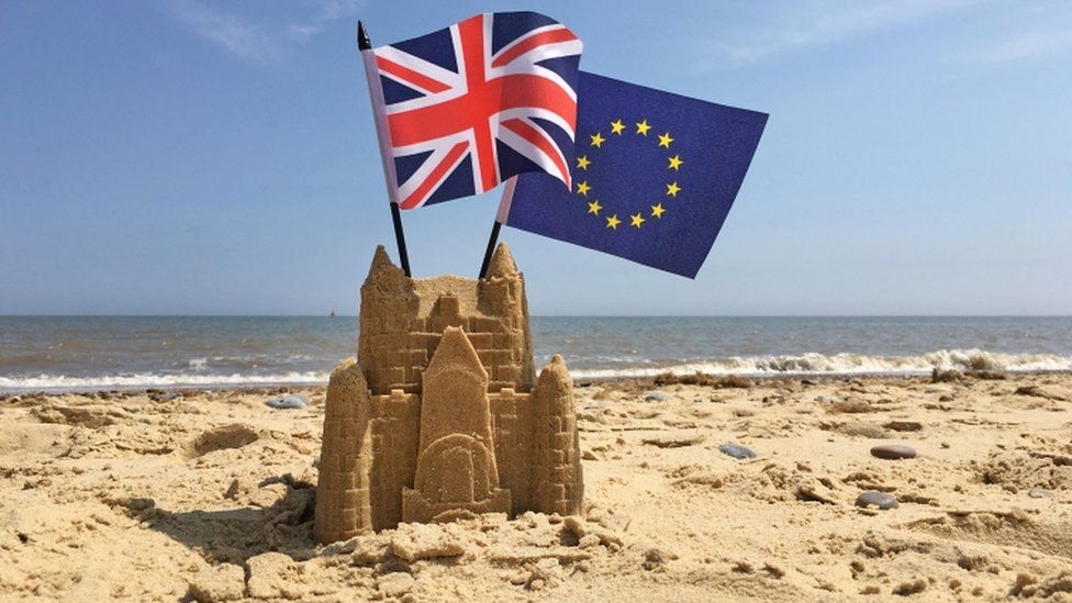 The Union flag and the European Union flag on a beach
