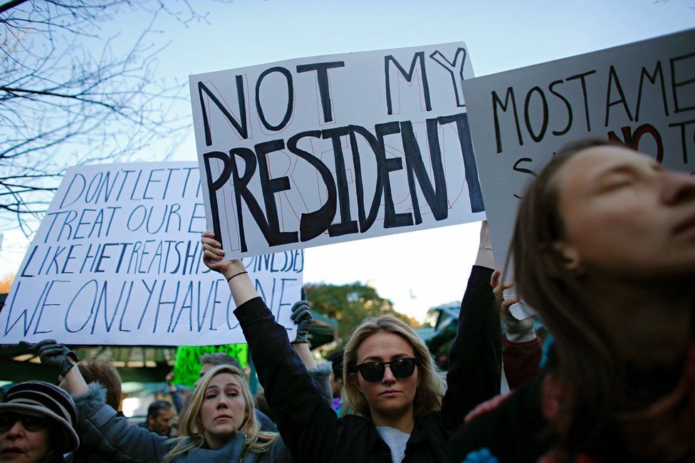 A woman holds a poster during a rally against US President-elect Donald Trump in Union Square, New York, 12 November