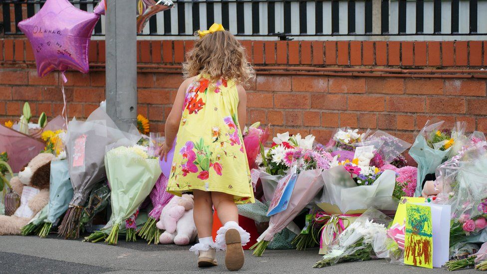 A young girl pays tribute in Kingsheath Avenue, Liverpool