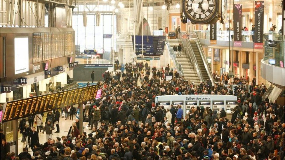 Commuters wait on the concourse of London Waterloo station