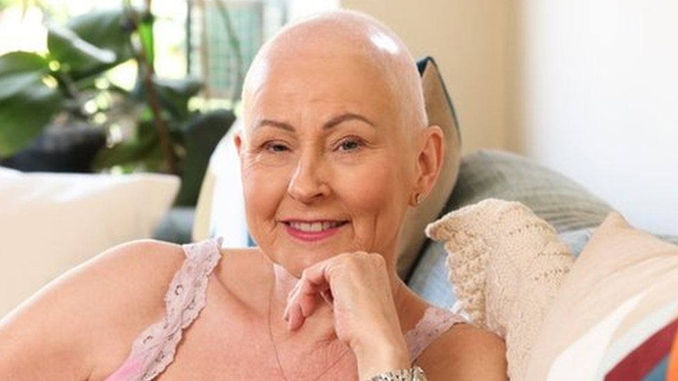 Pamela Ballentine sat on a sofa not wearing her wig