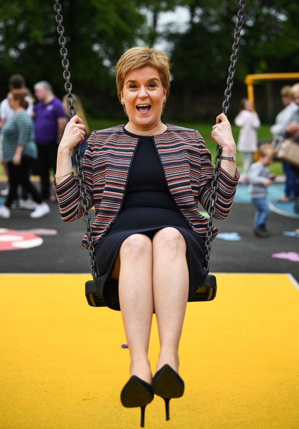 First Minister Nicola Sturgeon sits on a swing