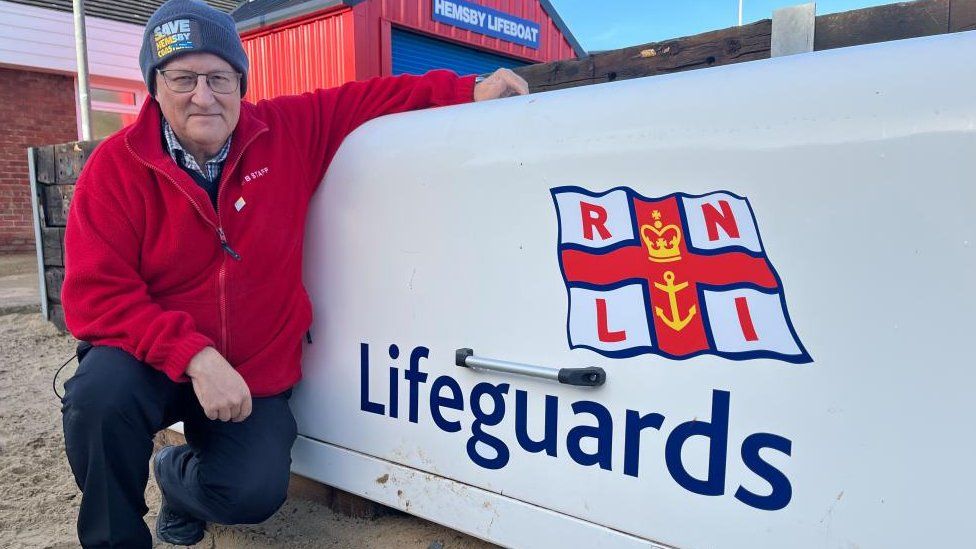 Lyndon Bevan pictured next to RNLI beach lifeguard equipment store.