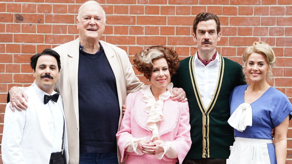 Hemi Yeroham as Manuel, John Cleese, Anna-Jane Casye as Sybil, Adam Jackson-Smith as Basil Fawlty and Victoria Fox as Polly pose before a Q&A session with the media ahead of the opening of Fawlty Towers The Play, which opens on Saturday, at the Apollo Theatre, central London. Picture date: Thursday May 2, 2024