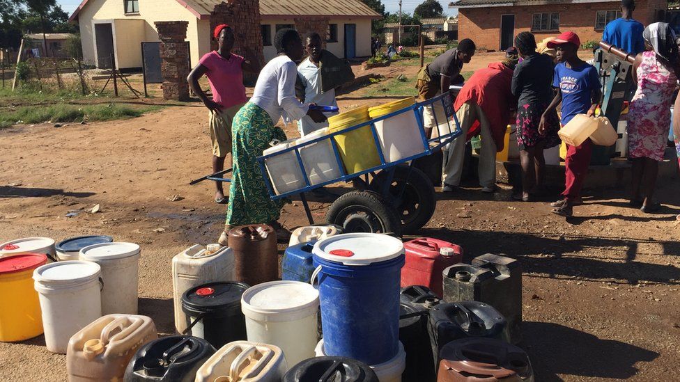 Residents queue up at a community borehole in Harare, Zimbabwe to fetch water.