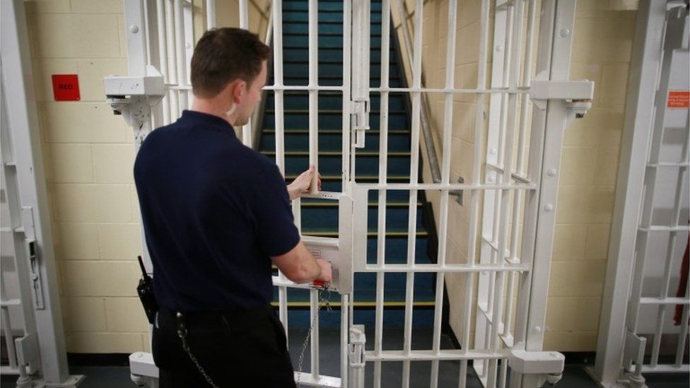 Prison officer locking a jail door