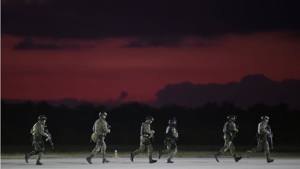 Members of the Mexican Army Special Forces run upon their arrival to the Airport of Culiacan, Sinaloa state, Mexico, on October 18, 2019