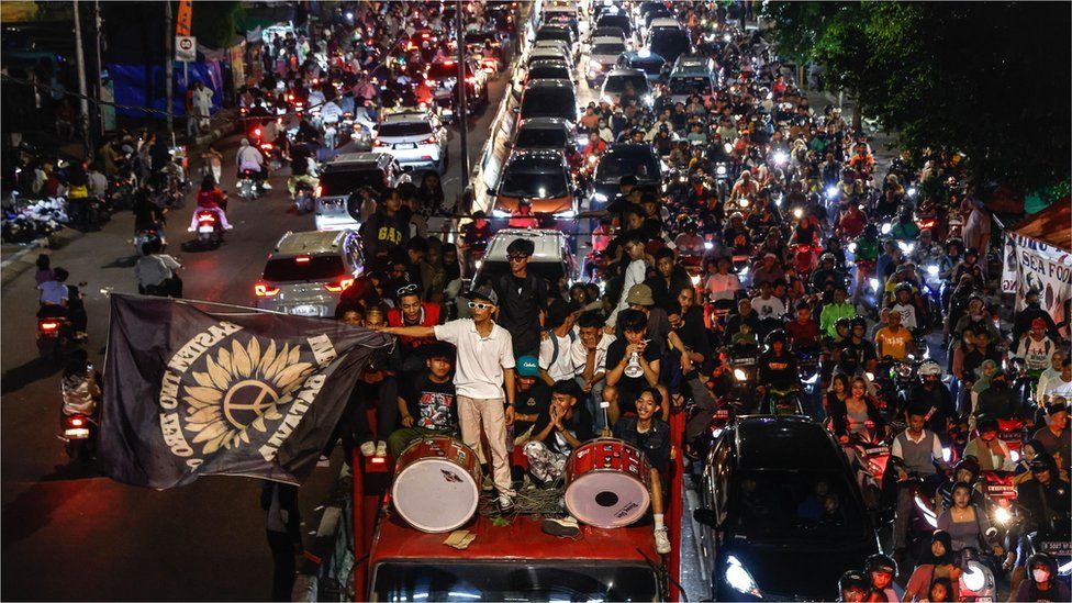 People on motorbikes and on top of of a truck celebrating in Jakarta, Indonesia