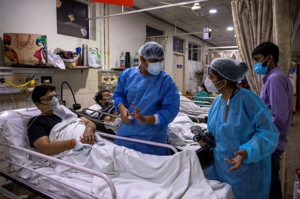 Rohan Aggarwal, 26, a resident doctor treating patients suffering from the coronavirus disease (COVID-19), talks to a colleague while tending to a patient during his 27-hour shift at Holy Family Hospital in New Delhi, India, May 1, 2021.