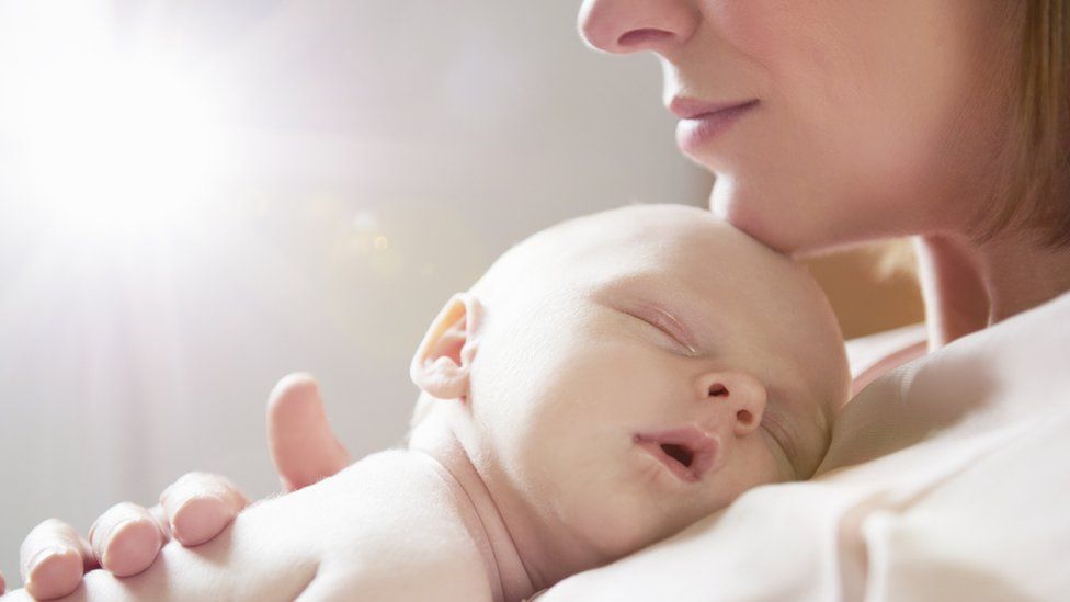 Baby sleeping on mother's chest - stock photo