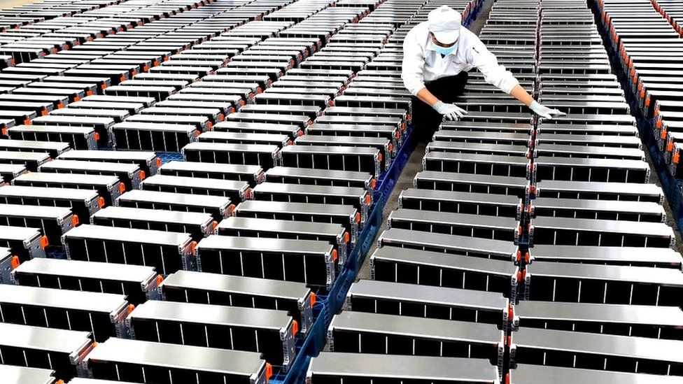A worker with car batteries at a factory for Xinwangda Electric Vehicle Battery Co. Ltd, which makes lithium batteries for electric cars