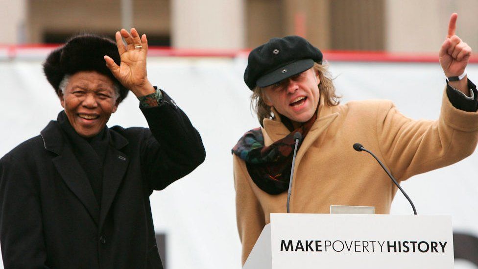 Former South African President Nelson Mandela (L) waves to the crowd with musician and campaigner Bob Geldof before making a speech endorsing the Make Poverty History' campaign during a mass rally in Trafalgar Square in London, England - 3 February 2005