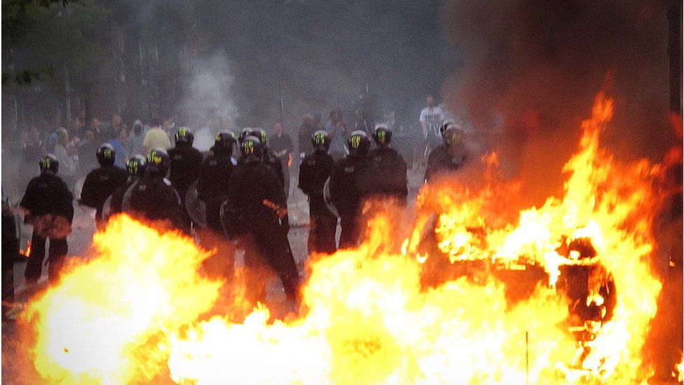 Riot police and flames