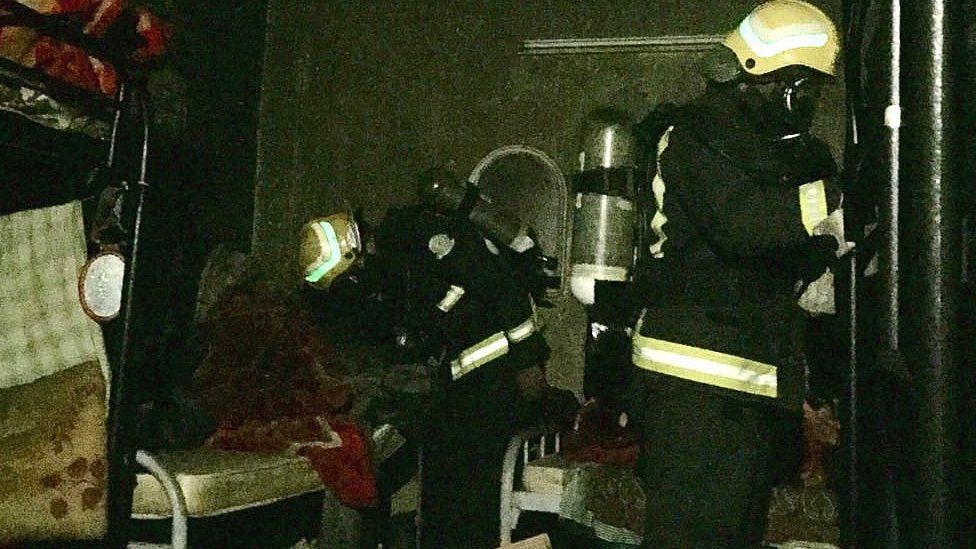 Firefighters examine the inside of the house in Najran