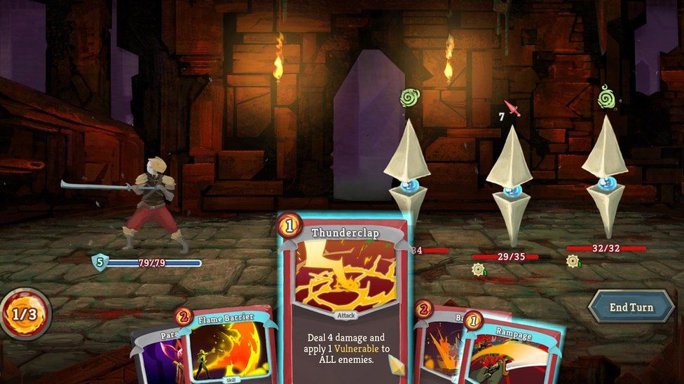 Скриншот из Slay the Spire, на котором изображен персонаж игрока, одетый в доспехи и держащий длинный тонкий меч перед средневековым замком с опущенным подъемным мостом. Три одинаковых врага - синий шар с двумя прикрепленными пирамидальными формами расположены напротив. На нижнем экране видна карта с надписью «Удар грома: нанесите 4 урона и нанесите 1 уязвимость ко всем врагам»