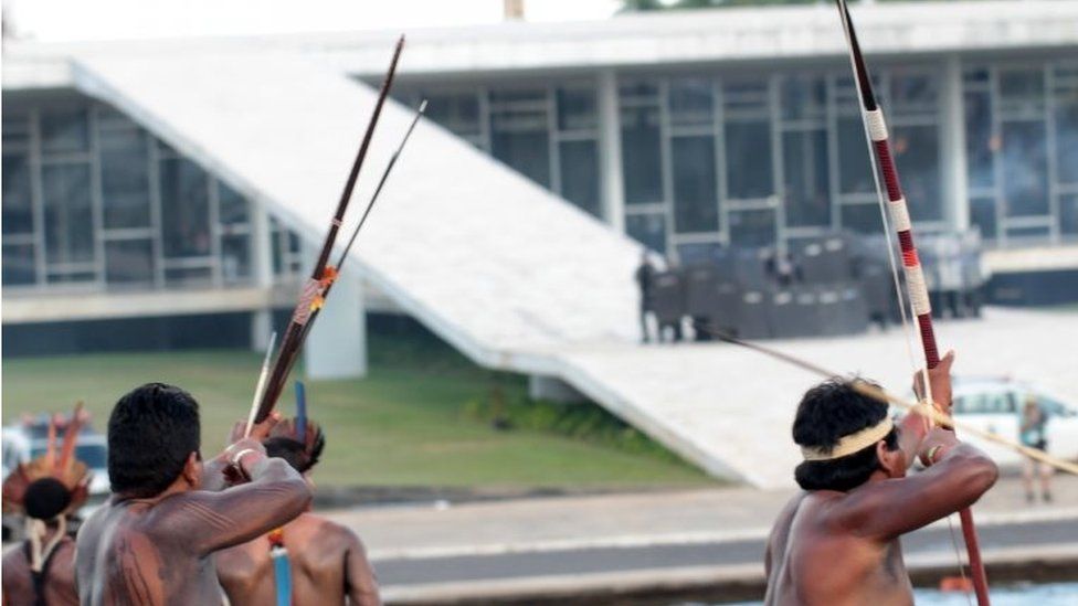 Brazilian indigenous people shoot arrows during a protest at Explanada dos Ministerios in Brasilia, Brazil, on 25 April 2017.