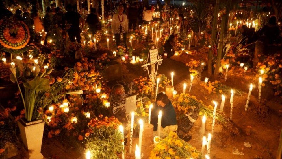 Семьи освещают могилы близких в пантеоне Атзомпа, штат Оахака, 1 ноября