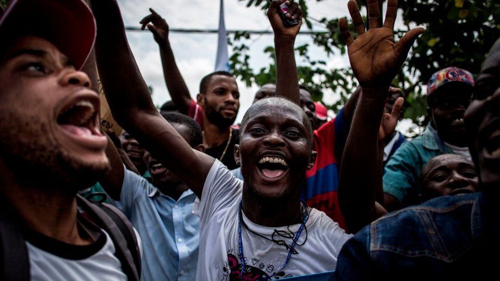 Supporters of Democratic Republic of Congo joint opposition presidential candidate Martin Fayulu sing and dance ahead of his arrival in Kinshasa to launch his campaign on November