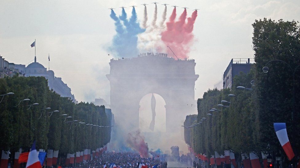The Patrouille de France jets, trailing smoke in the colours of the national flag, fly over the Champs-Elysées on 16 July 2018 in Paris