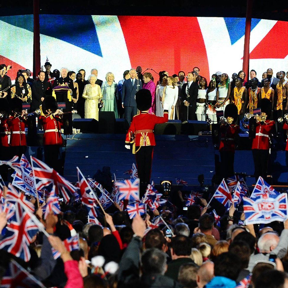 Королева Елизавета II на сцене возле Букингемского дворца в Лондоне с Чарльзом, Камиллой и множеством поп-звезд на концерте в честь Бриллиантового юбилея во время празднования ее 60-летия как суверена.