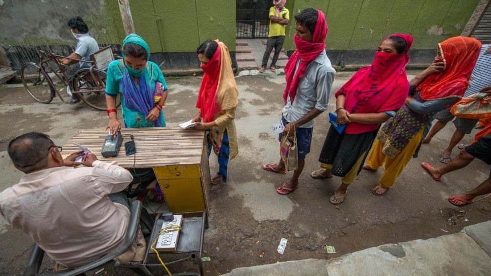 People stand in queue amidst the process of receiving free ration. Government Ration shops distributed 5Kg free food grain under the Pradhan Mantri Garib Anna Yojana (PMGAY) during the Covid-19 crisis