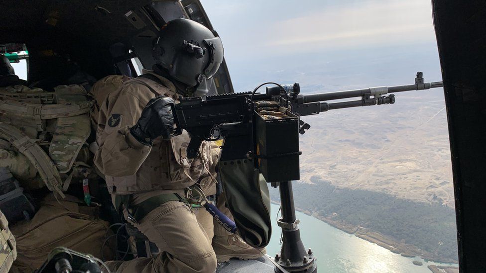 A coalition soldier in a helicopter
