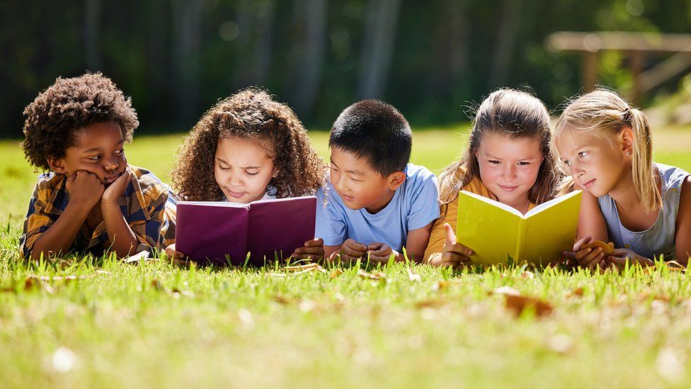 Kids reading books in the garden.