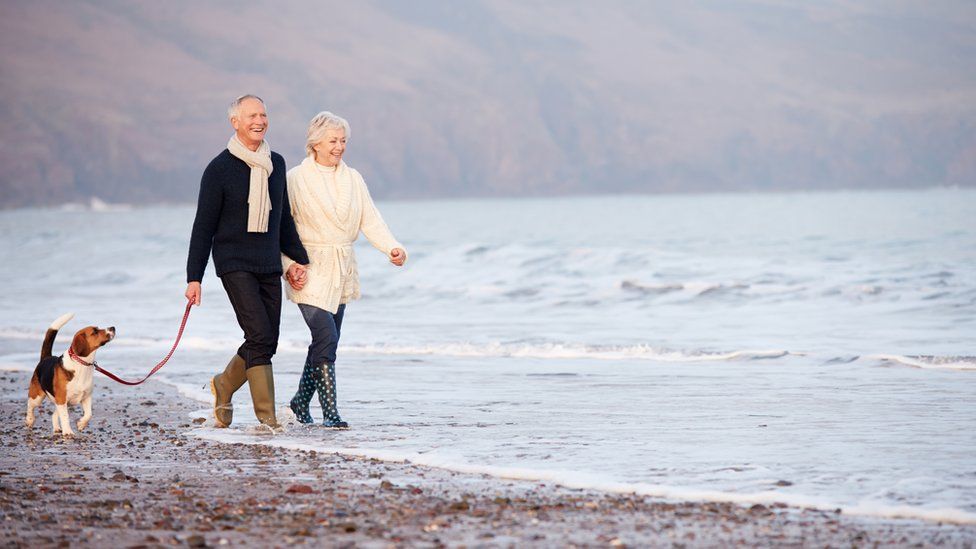 older couple walking on beach