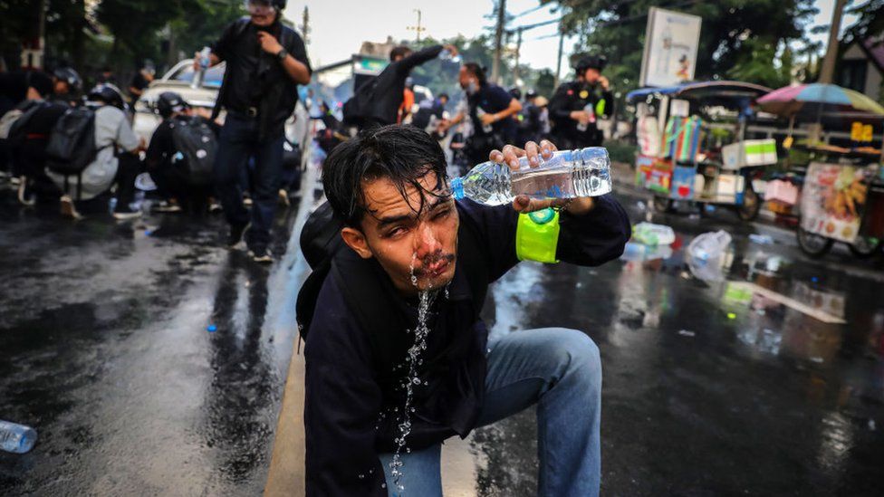 A protester who was exposed to tear gas washes his face outside parliament on 17 November 2020 in Bangkok