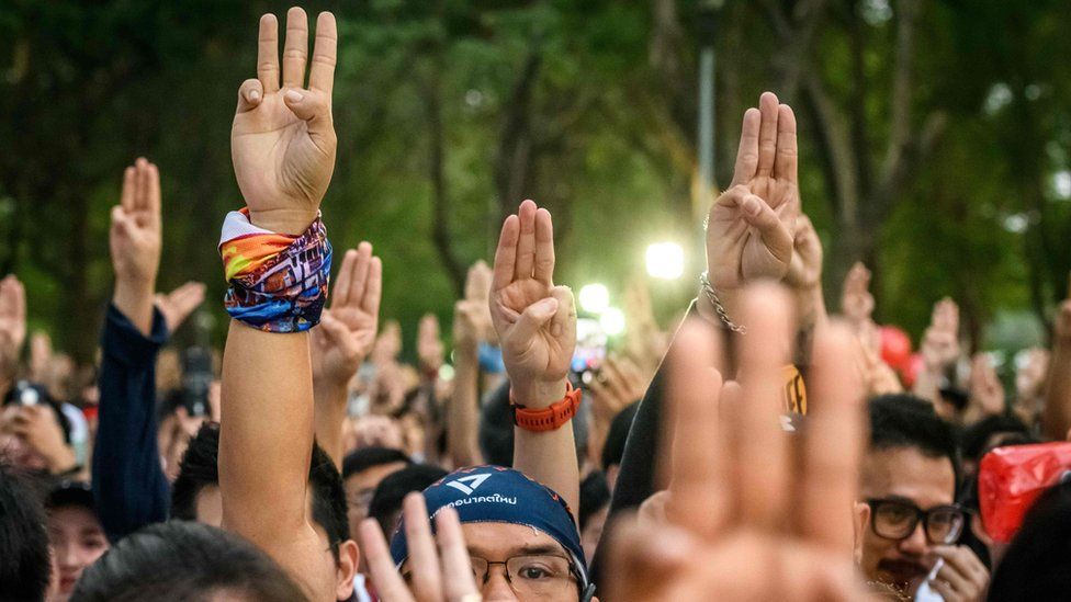 Participants gesture a three-finger salute at the start of a "run against dictatorship" in Bangkok