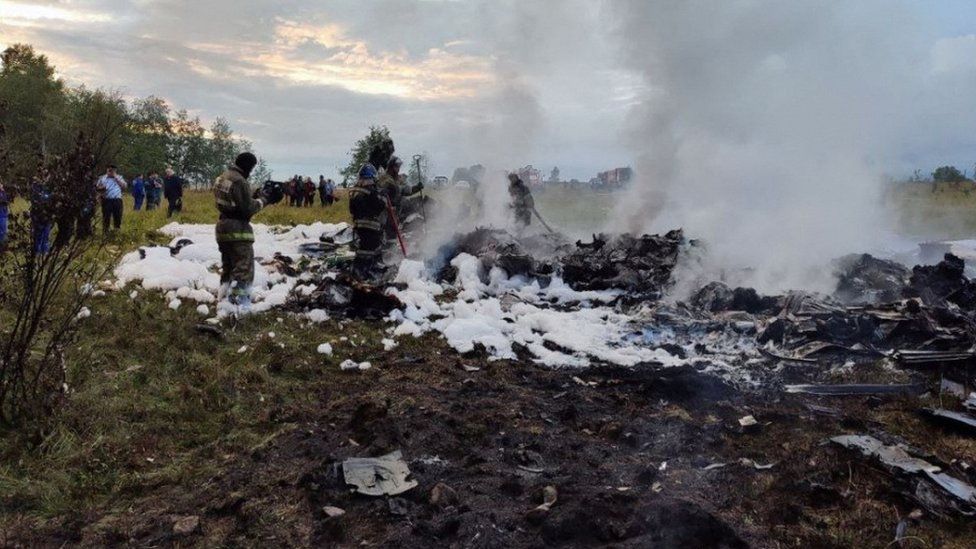 Firefighters work amid aircraft wreckage at an accident scene following the crash of a private jet in the Tver region