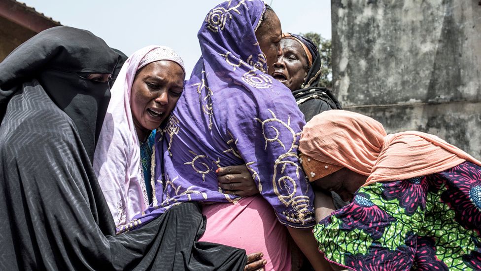Women hug each other in grief in Conakry, Guinea - Sunday 1 March 2020