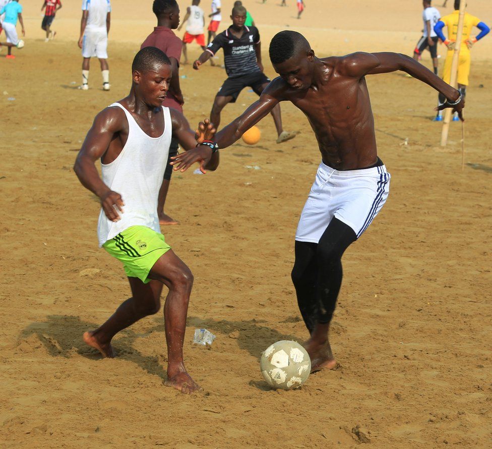 Young people on Sunday take to playing beach soccer in Monrovia, Liberia's capital