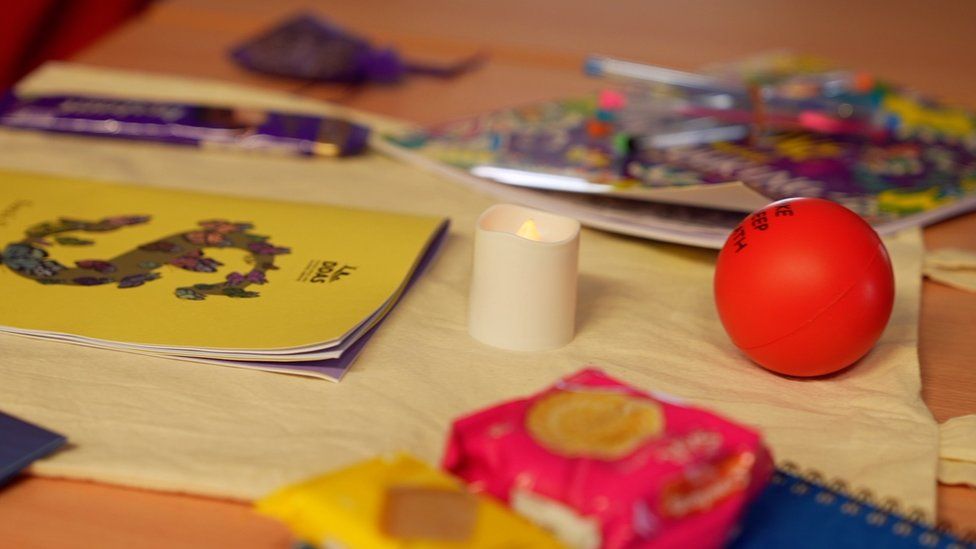 divers objets, dont une bougie, une balle anti-stress et des livres colorés