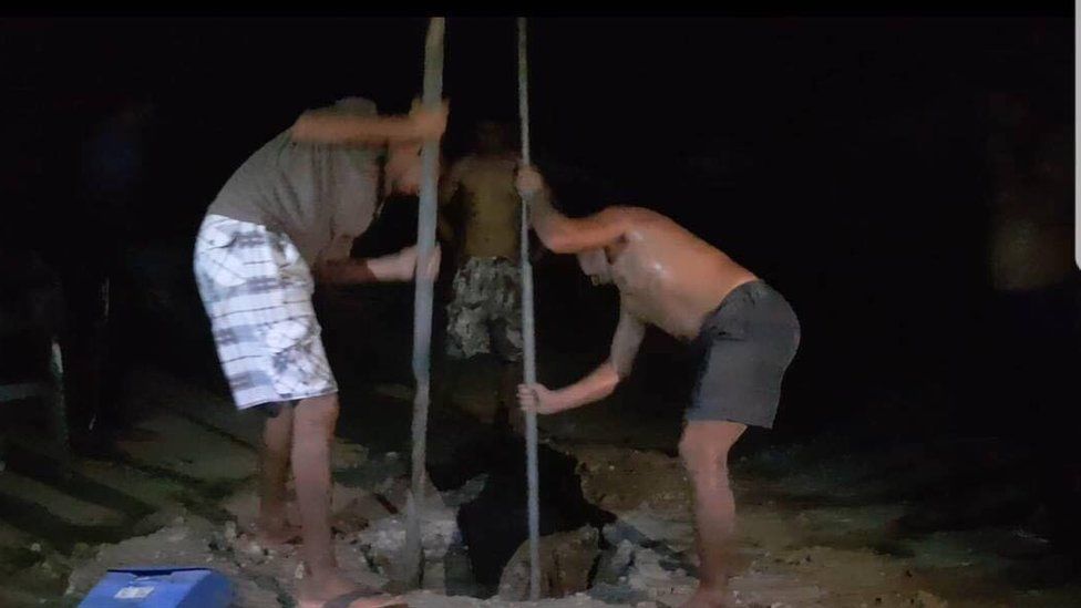 Men dig a hole in an attempt to find fresh water
