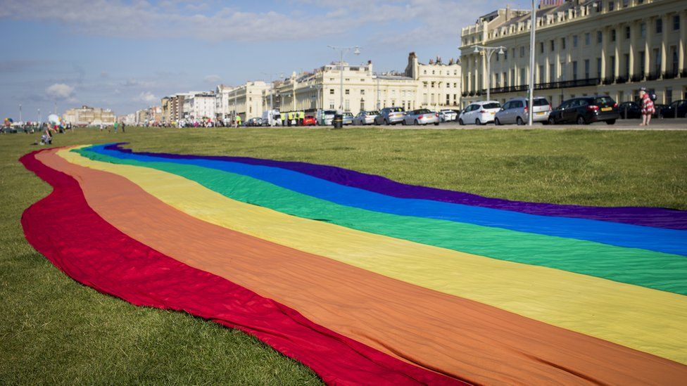 A large rainbow Pride banner is spread out ahead of the annual Brighton Pride parade