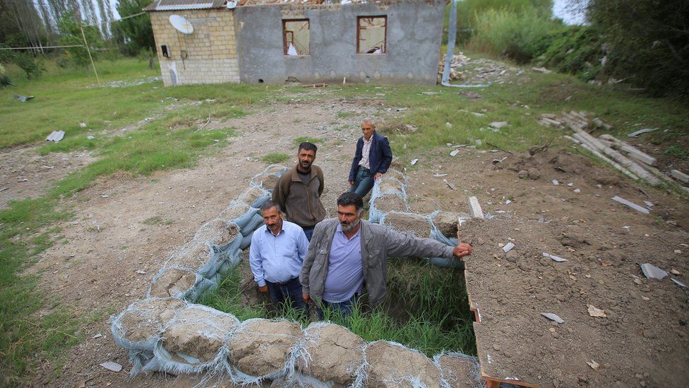 Local residents gather outside a dugout in readiness to take shelter during the fighting over the breakaway region of Nagorno-Karabakh, 30 September 2020