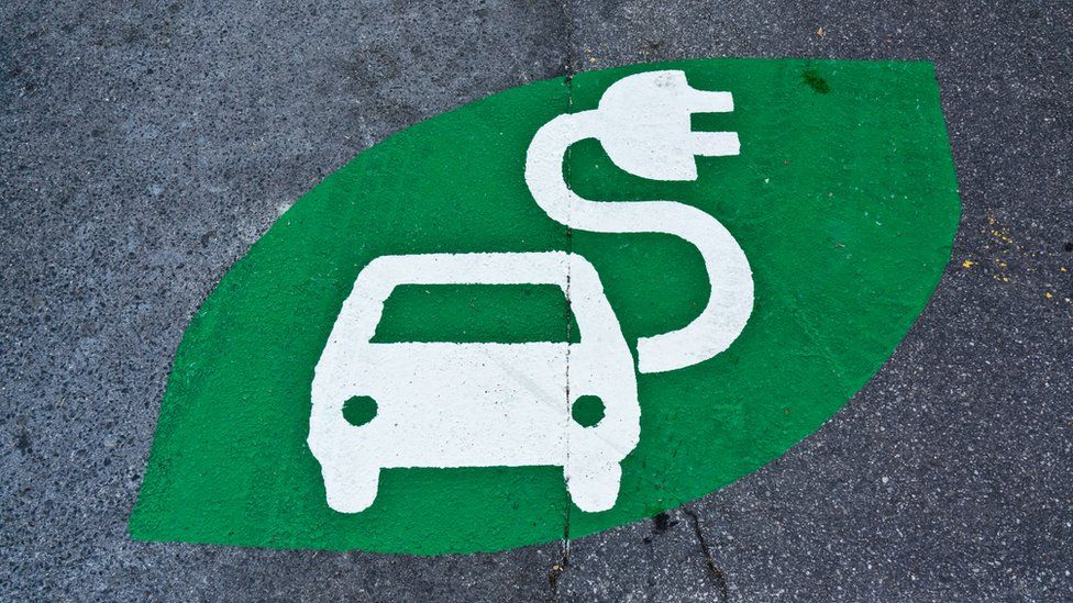 Green electric car charging sign painted on a road
