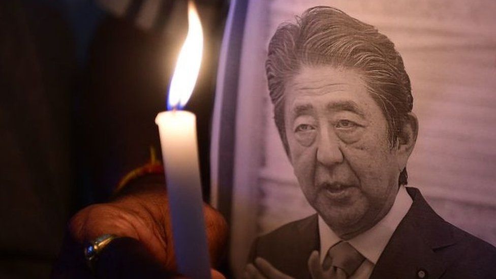 Members of the Japan information and study centre hold a candlelight vigil to pay tribute to the late former prime minister of Japan Shinzo Abe, at Ahmedabad Management Association in Ahmedabad on July 9, 2022, after Abe was shot dead during a campaign speech on July 8 in Nara.