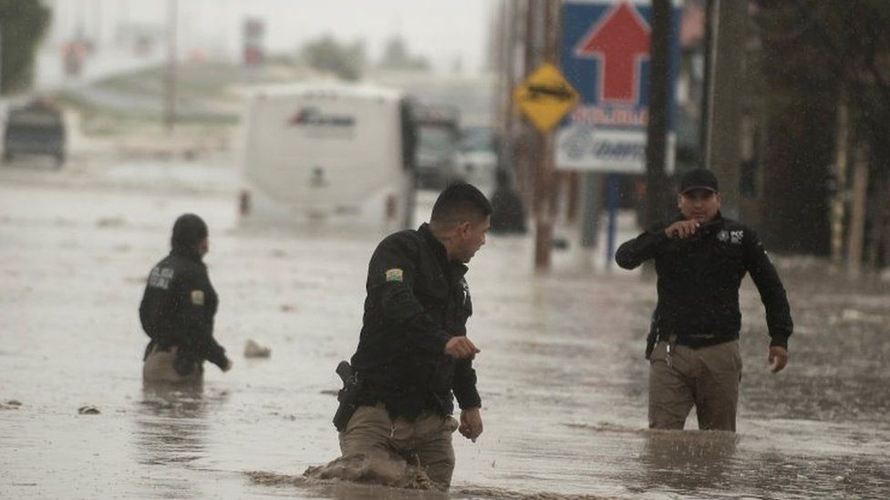 Police officers wade through severe floods, caused by heavy rains, affecting the city of Saltillo in the northern state of Coahuila, Mexico 26 July 2020
