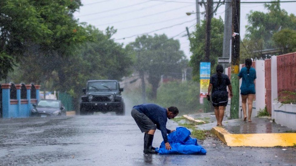 Person takes blue tarp from road