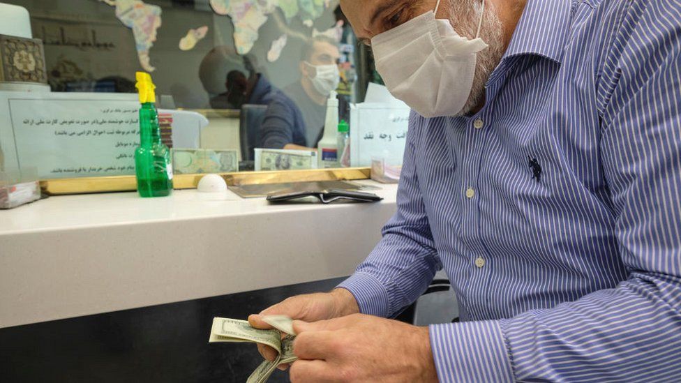 Man counting money in an exchange shop in Tehran