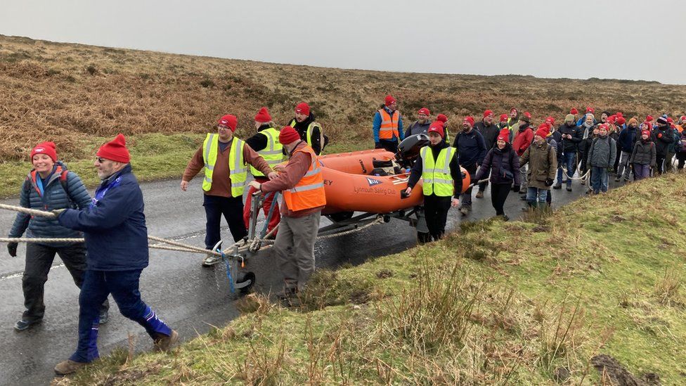 Volunteers carrying a lifeboat