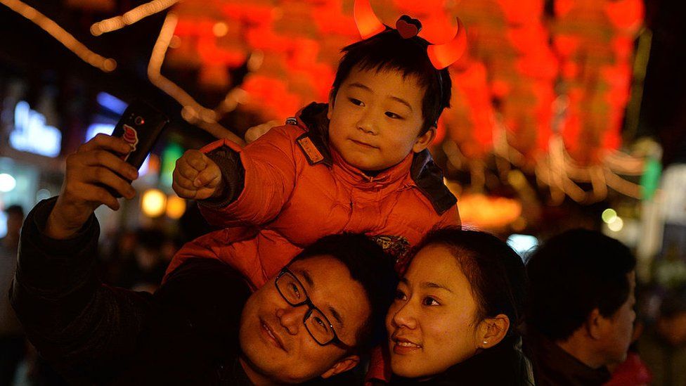 A Chinese family poses for a photo in front of Lantern Festival decorations in Shanghai