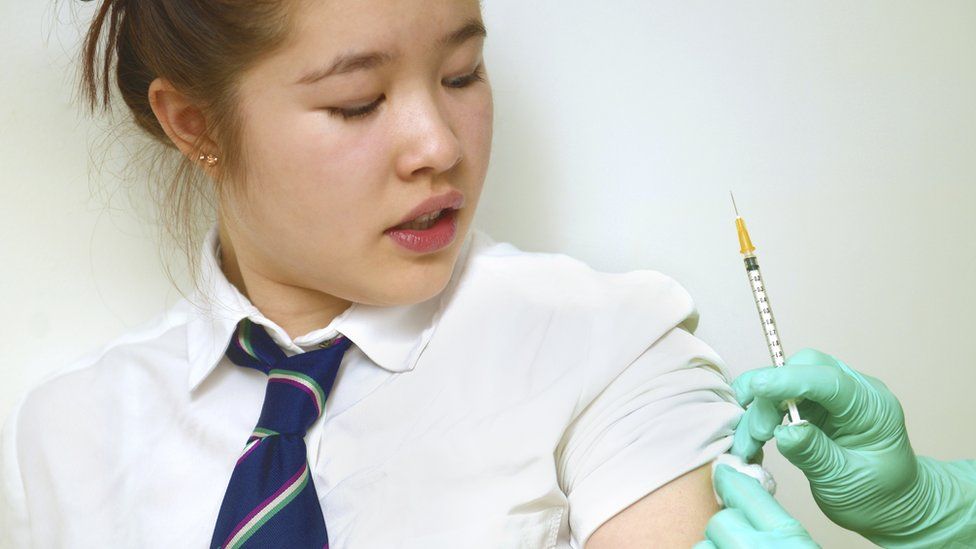 Школьница получает вакцину